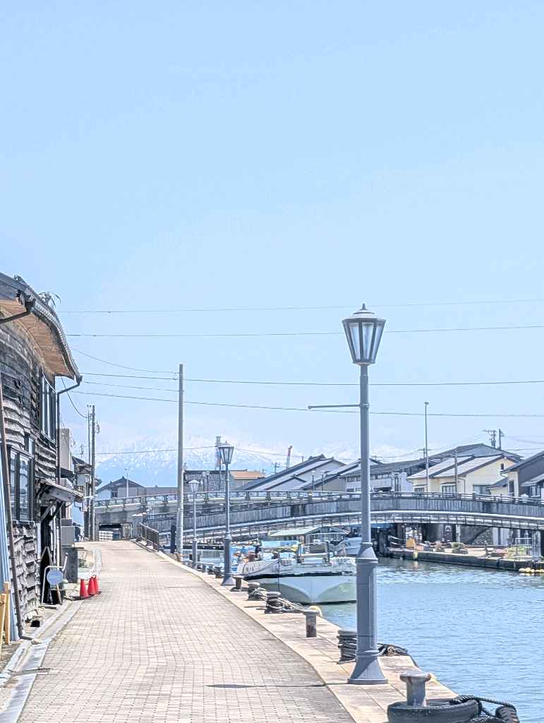 新湊内川エリア - 内川の両岸には漁船が係留され、街並みと奥に見える立山連峰は素敵な眺め
中の橋からの眺めが個人的には好き！

川沿いにはカフェやホテルもあるので、次は泊まって夜の眺めを楽しむのも悪く… - photo 11